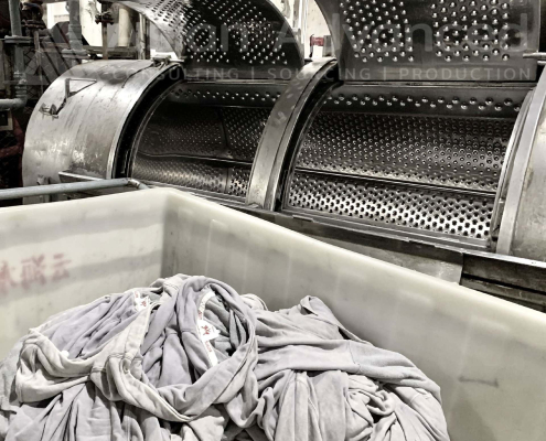 Ein Schritt im Produktionsprozess in Textilfabrik ist Kleidungsstücke zu waschen
